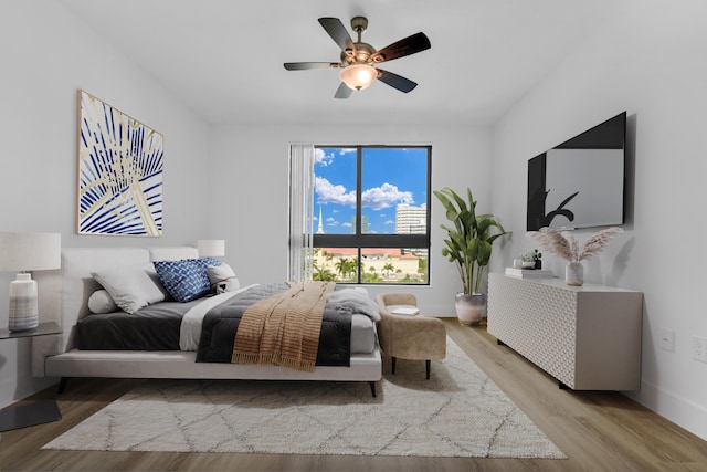 bedroom featuring light wood-type flooring, baseboards, and a ceiling fan