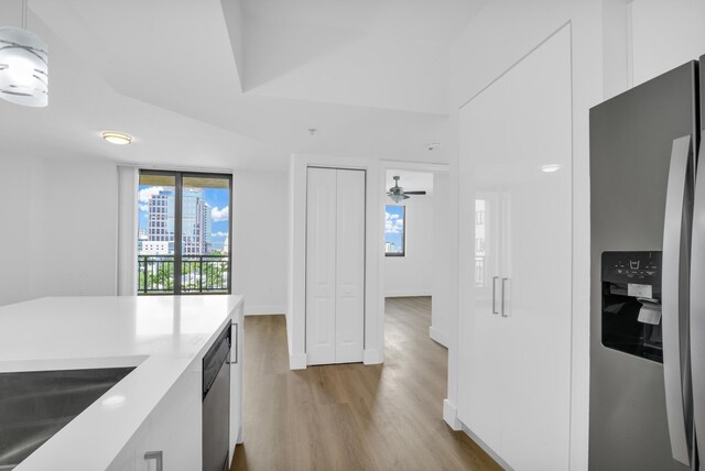 kitchen featuring pendant lighting, white cabinets, sink, and dishwasher