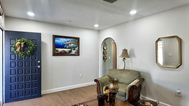 foyer featuring wood-type flooring and a textured ceiling