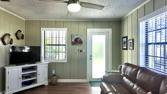 living room with dark hardwood / wood-style flooring, ornamental molding, and ceiling fan