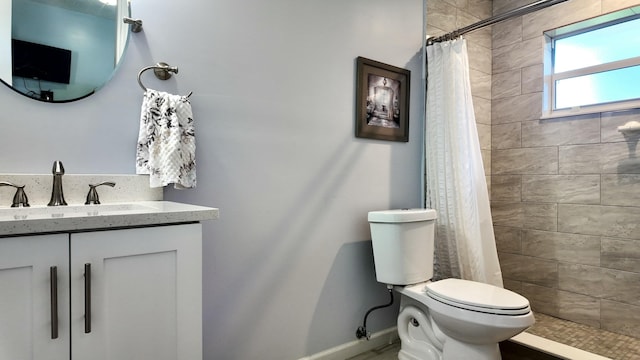 bathroom featuring vanity, curtained shower, and toilet