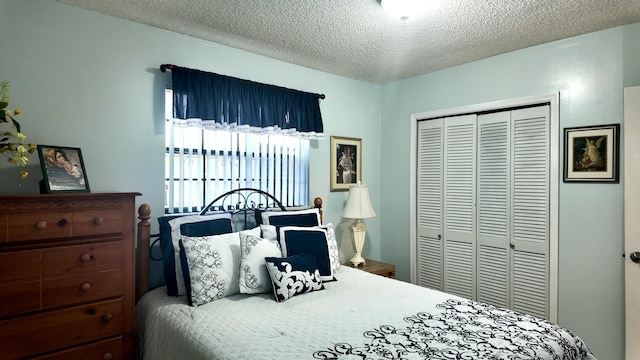 bedroom with a textured ceiling and a closet