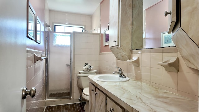 bathroom with tile walls, tile patterned flooring, vanity, toilet, and walk in shower