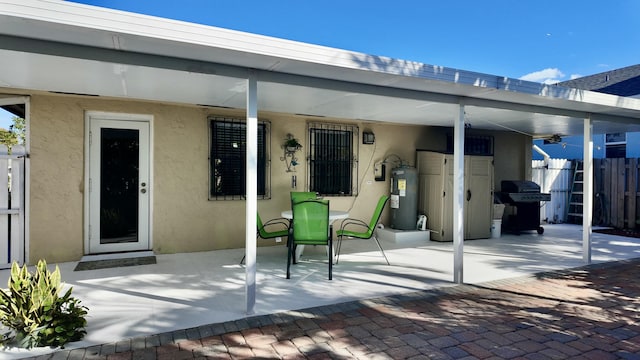 exterior space with electric water heater and a patio