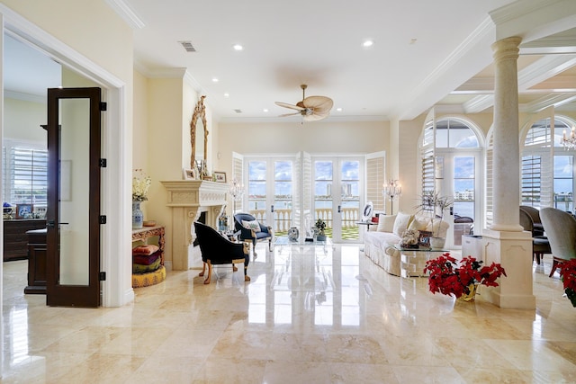 living room featuring crown molding, plenty of natural light, and decorative columns