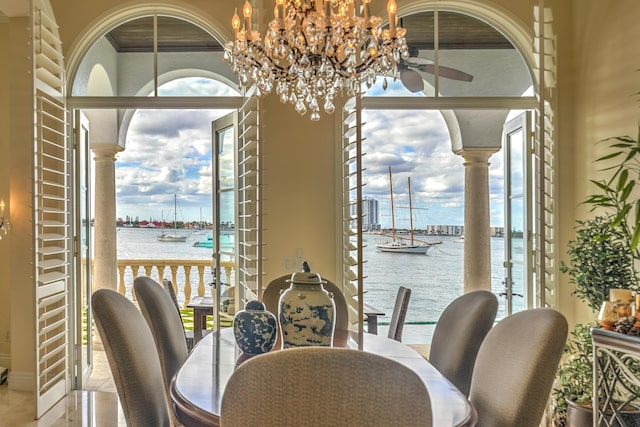 dining room with a water view and a notable chandelier