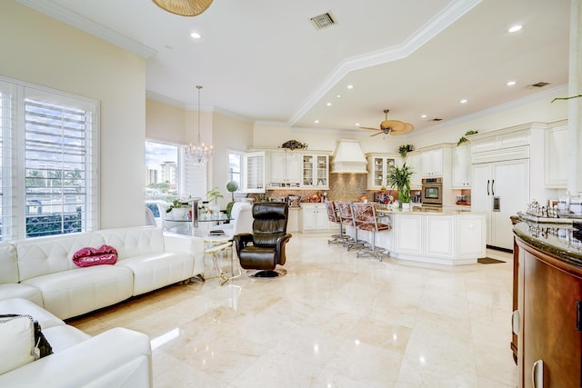 living room featuring crown molding and ceiling fan with notable chandelier