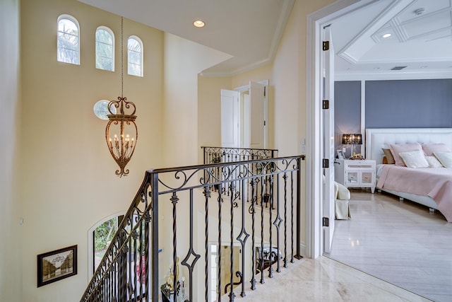 corridor with crown molding and a chandelier