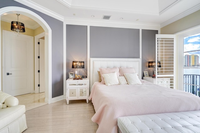 bedroom featuring an inviting chandelier, light hardwood / wood-style flooring, and ornamental molding