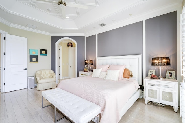 bedroom featuring ceiling fan, ornamental molding, a tray ceiling, and light hardwood / wood-style floors