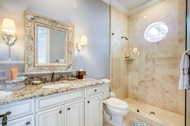 bathroom with vanity, crown molding, toilet, and tiled shower