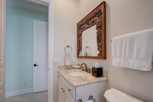 bathroom featuring vanity, crown molding, and toilet