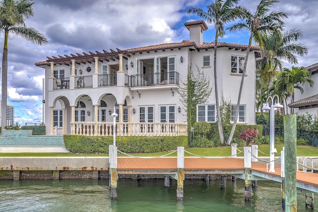 rear view of property with a water view and a balcony