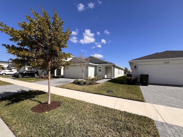 ranch-style house with a garage and a front lawn