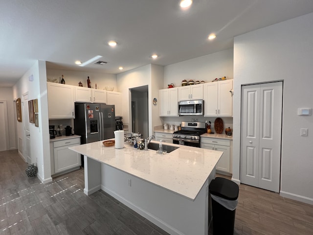 kitchen featuring an island with sink, stainless steel appliances, sink, and white cabinets