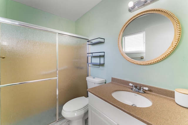 bathroom with vanity, toilet, and a shower with shower door