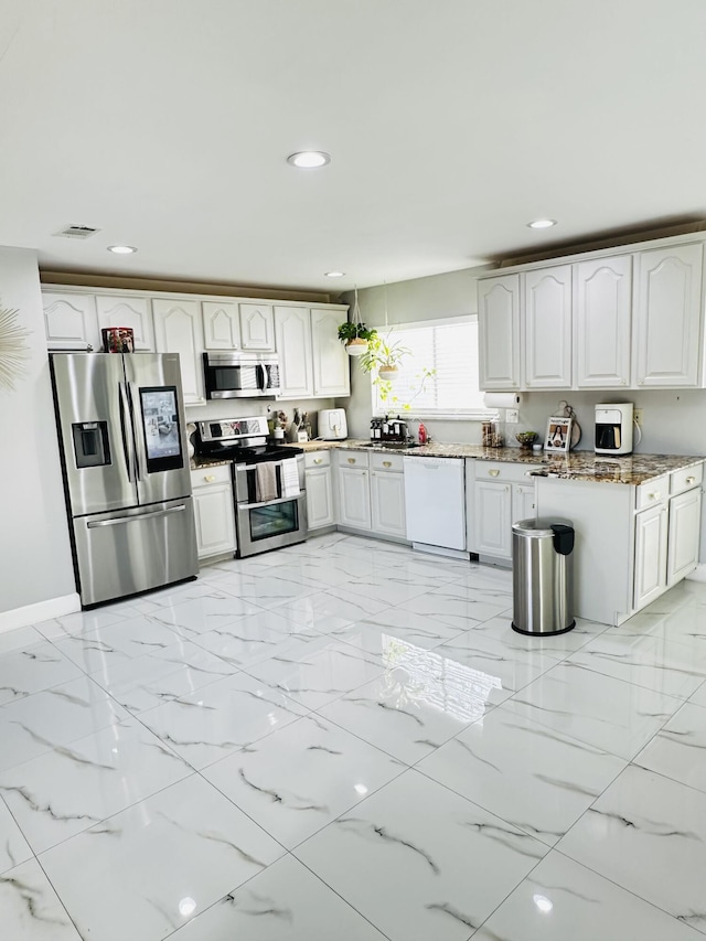 kitchen featuring stone counters, white cabinetry, and appliances with stainless steel finishes