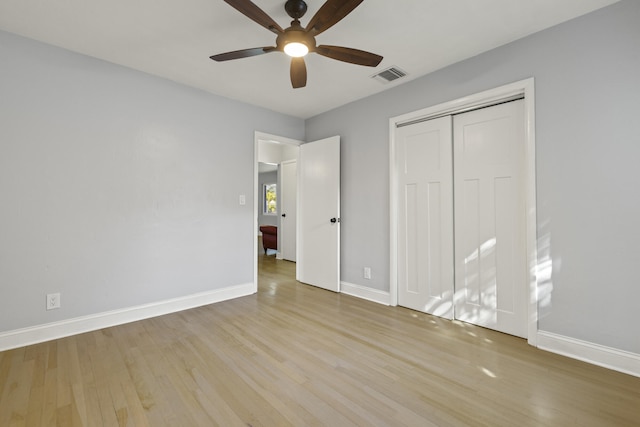 unfurnished bedroom with light hardwood / wood-style flooring, a closet, and ceiling fan