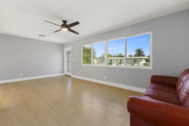 living room featuring light hardwood / wood-style flooring and ceiling fan