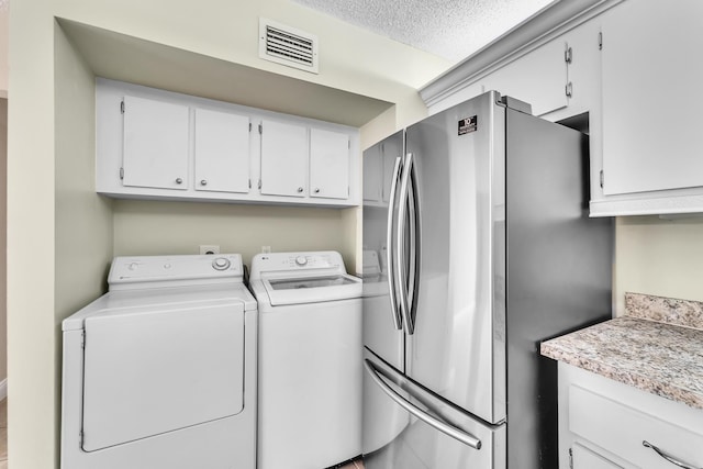 laundry room featuring independent washer and dryer and a textured ceiling