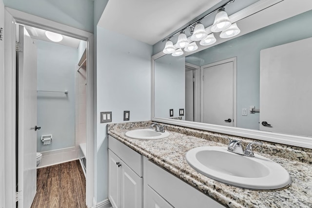 full bathroom with wood-type flooring, bathtub / shower combination, vanity, and toilet