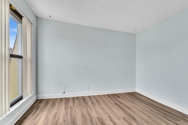 empty room featuring a textured ceiling and light hardwood / wood-style floors