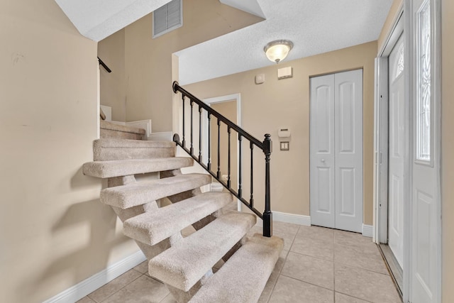 entrance foyer featuring a textured ceiling and light tile patterned flooring