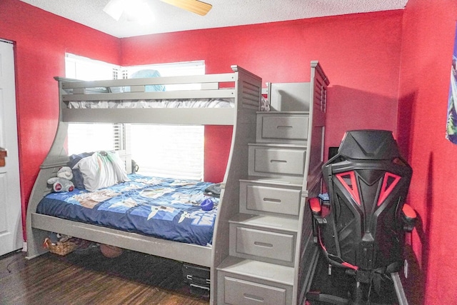 bedroom featuring ceiling fan, wood-type flooring, and a textured ceiling