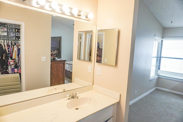 bathroom featuring vanity, lofted ceiling, and a textured ceiling