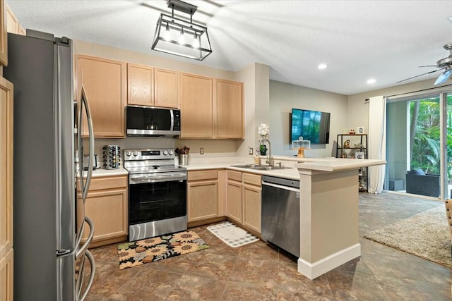 kitchen with stainless steel appliances, sink, light brown cabinets, and kitchen peninsula