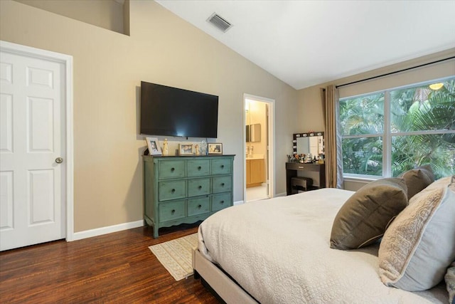 bedroom with dark hardwood / wood-style flooring, connected bathroom, and lofted ceiling