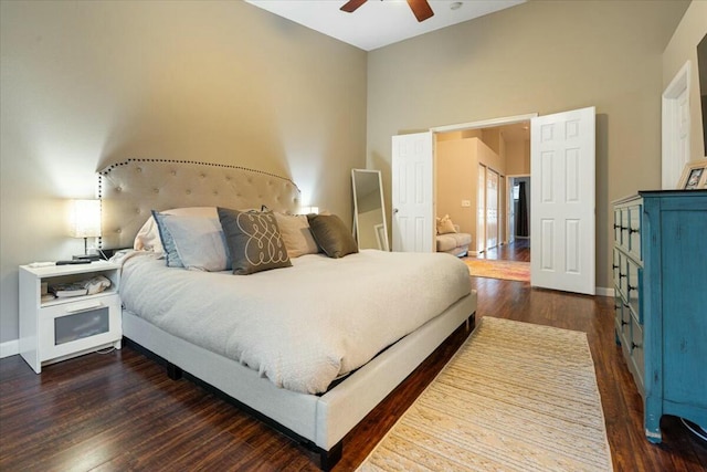 bedroom with dark hardwood / wood-style flooring, high vaulted ceiling, and ceiling fan