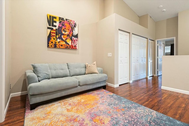 living room with dark hardwood / wood-style flooring and high vaulted ceiling