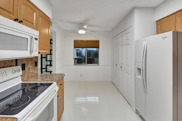 kitchen featuring ceiling fan, light tile patterned floors, a textured ceiling, and white appliances