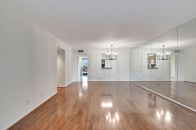 unfurnished living room featuring hardwood / wood-style flooring and a notable chandelier