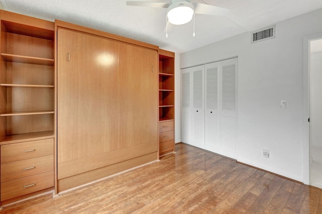 unfurnished bedroom featuring ceiling fan, hardwood / wood-style floors, and a closet