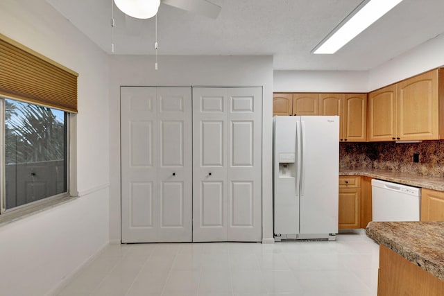 kitchen with light tile patterned floors, white appliances, and decorative backsplash