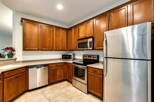 kitchen with stainless steel appliances, sink, and light tile patterned floors