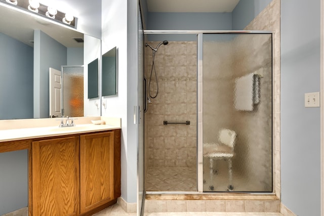 bathroom featuring tile patterned flooring, vanity, and walk in shower