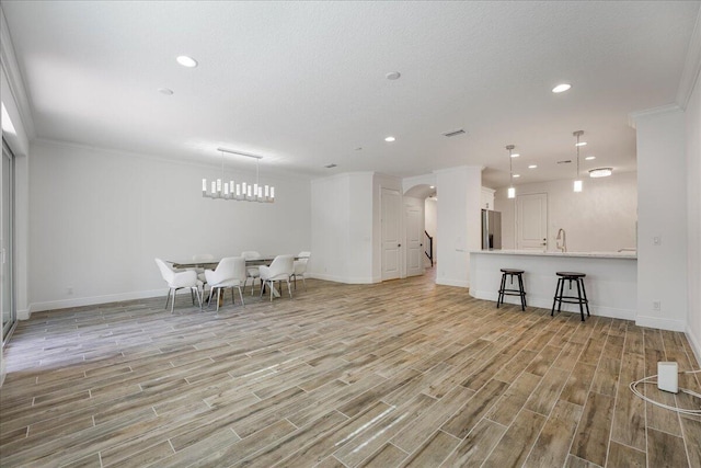 interior space with ornamental molding, sink, and a textured ceiling