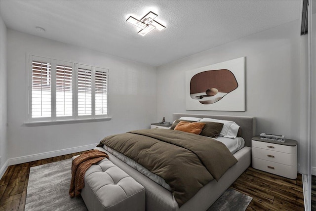 bedroom featuring dark hardwood / wood-style flooring and a textured ceiling