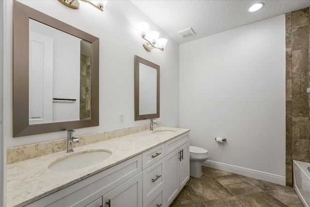 bathroom featuring vanity, toilet, and a textured ceiling