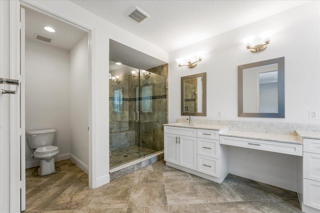 bathroom featuring vanity, a shower with shower door, a textured ceiling, and toilet