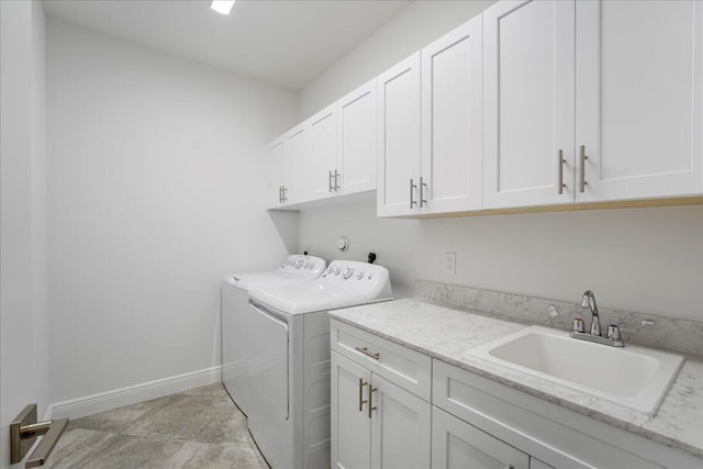 washroom with sink, washing machine and dryer, and cabinets