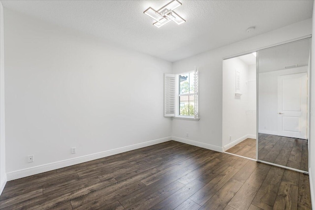 unfurnished bedroom with dark wood-type flooring and a textured ceiling