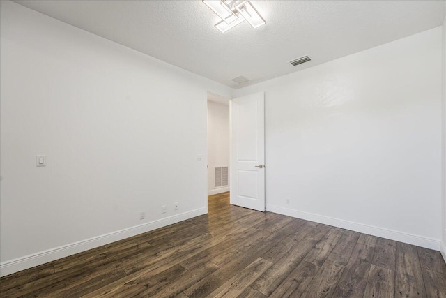 empty room featuring dark hardwood / wood-style flooring and a textured ceiling