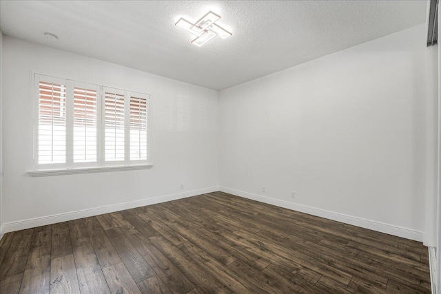 unfurnished room featuring dark hardwood / wood-style floors and a textured ceiling