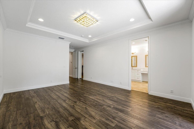 spare room featuring dark wood-type flooring, ornamental molding, and a raised ceiling