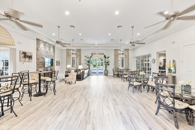 dining area featuring crown molding, light hardwood / wood-style flooring, and french doors