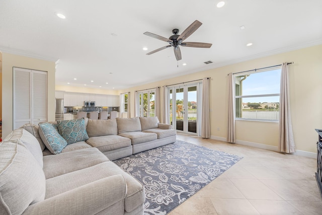 tiled living room featuring ornamental molding, french doors, and ceiling fan